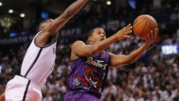 Dec 17, 2014; Toronto, Ontario, CAN; Toronto Raptors guard Kyle Lowry (7) jumps to score past Brooklyn Nets forward Joe Johnson (7) in the fourth quarter at Air Canada Centre. Mandatory Credit: Peter Llewellyn-USA TODAY Sports