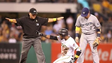 Sep 2, 2016; Pittsburgh, PA, USA; Pittsburgh Pirates left fielder Starling Marte (6) reacts at being called safe with a double by umpire Clint Fagen (L) as Milwaukee Brewers second baseman Scooter Gennett (2) looks on during the fourth inning at PNC Park. Mandatory Credit: Charles LeClaire-USA TODAY Sports
