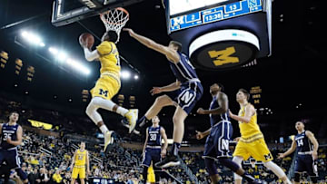 Feb 24, 2016; Ann Arbor, MI, USA; Michigan Wolverines guard Muhammad-Ali Abdur-Rahkman (12) shoots the ball past Northwestern Wildcats forward Gavin Skelly (44) in the first half at Crisler Center. Mandatory Credit: Rick Osentoski-USA TODAY Sports