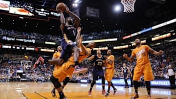 Feb 28, 2014; Phoenix, AZ, USA; Phoenix Suns power forward Markieff Morris (11) draws a charging foul against New Orleans Pelicans small forward Tyreke Evans (1) during the second half at US Airways Center. The Phoenix Suns won the game 116-104. Mandatory Credit: Joe Camporeale-USA TODAY Sports