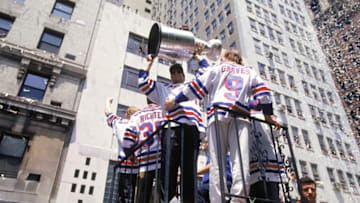 Hockey player Mark Messier of the New York Rangers holds the Stanley Cup aloft as he and his teammates celebrate their victory over the Vancouver Canucks earlier in the week with a ticker-tape parade in New York, New York, June 17, 1994. (Photo by Bruce Bennett Studios via Getty Images Studios/Getty Images)