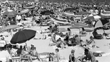 UNITED STATES - CIRCA 1950s: Crowds of relaxing on beach. (Photo by H. Armstrong Roberts/Retrofile/Getty Images)