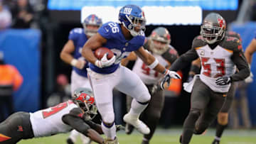 EAST RUTHERFORD, NJ - NOVEMBER 18: Running back Saquon Barkley #26 of the New York Giants carries the ball for a first down against the Tampa Bay Buccaneers during the third quarter at MetLife Stadium on November 18, 2018 in East Rutherford, New Jersey. (Photo by Elsa/Getty Images)