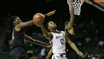 Mar 4, 2021; Waco, Texas, USA; Baylor Bears guard Jared Butler (12) drives the lane on Oklahoma State Cowboys forward Kalib Boone (22) and guard Avery Anderson III (0) during the first half at Ferrell Center. Mandatory Credit: Raymond Carlin III-USA TODAY Sports