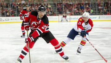 Dec 6, 2015; Newark, NJ, USA; New Jersey Devils left wing Patrik Elias (26) passing the puck as Florida Panthers center Jonathan Huberdeau (11) defends in the second period at Prudential Center. Mandatory Credit: William Hauser-USA TODAY Sports