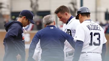 Apr 11, 2016; Detroit, MI, USA; Detroit Tigers catcher James McCann (34) is examined by manager Brad Ausmus (left) and trainer Kevin Rand and first base coach Omar Vizquel (13) after suffering an injury in the fifth inning against the Pittsburgh Pirates at Comerica Park. Mandatory Credit: Rick Osentoski-USA TODAY Sports