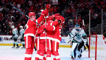 Teammates celebrate with center Dylan Larkin, who scored against Seattle, during the third period of the Wings' 5-4 overtime loss on Tuesday, Oct. 24, 2023, at Little Caesars Arena.