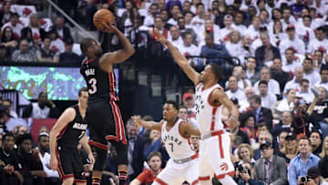 May 3, 2016; Toronto, Ontario, CAN; Miami Heat guard Dwyane Wade (3) takes a shot over Toronto Raptors guards Norman Powell (24) and Kyle Lowry (7) in game one of the second round of the NBA Playoffs at Air Canada Centre. Mandatory Credit: Dan Hamilton-USA TODAY Sports