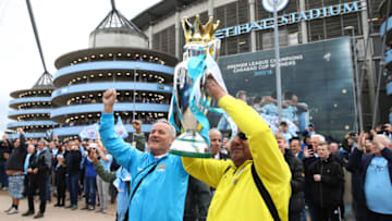 MANCHESTER, ENGLAND - APRIL 22: Manchester City fans pose with a replica trophy during the Premier League match between Manchester City and Swansea City at Etihad Stadium on April 22, 2018 in Manchester, England. (Photo by Clive Brunskill/Getty Images)