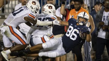 STATE COLLEGE, PA - SEPTEMBER 18: Brenton Strange #86 of the Penn State Nittany Lions is shoved out of bounds near the end zone by Zion Puckett #11 and Smoke Monday #21 of the Auburn Tigers during the second half at Beaver Stadium on September 18, 2021 in State College, Pennsylvania. (Photo by Scott Taetsch/Getty Images)