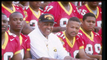 13 Aug 1997: Coach Eddie Robinson of the Grambling State Tigers sits with his team during Media Day in Grambling, Louisiana.