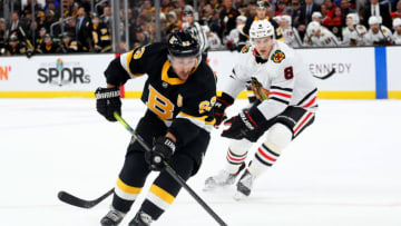 BOSTON, MASSACHUSETTS - DECEMBER 05: Brad Marchand #63 of the Boston Bruins skates against Dominik Kubalik #8 of the Chicago Blackhawks during the third period at TD Garden on December 05, 2019 in Boston, Massachusetts. (Photo by Maddie Meyer/Getty Images)