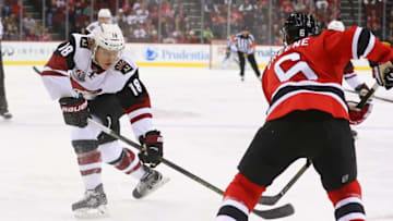 Oct 25, 2016; Newark, NJ, USA; Arizona Coyotes center Christian Dvorak (18) plays the puck as New Jersey Devils defenseman Andy Greene (6) defends during the first period at Prudential Center. Mandatory Credit: Ed Mulholland-USA TODAY Sports