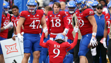 LAWRENCE, KANSAS - NOVEMBER 11: Quarterback Jason Bean #9 of the Kansas Jayhawks is helped to his feet by teammates during the 1st half of the game against the Texas Tech Red Raiders at David Booth Kansas Memorial Stadium on November 11, 2023 in Lawrence, Kansas. (Photo by Jamie Squire/Getty Images)