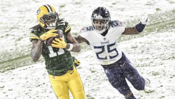 Dec 27, 2020; Green Bay, Wisconsin, USA; Green Bay Packers wide receiver Davante Adams (17) catches a touchdown pass against Tennessee Titans cornerback Adoree' Jackson (25) in the second quarter at Lambeau Field. Mandatory Credit: Benny Sieu-USA TODAY Sports