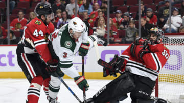 CHICAGO, IL - NOVEMBER 18: Charlie Coyle #3 of the Minnesota Wild and Jan Rutta #44 of the Chicago Blackhawks watch for the puck in front of goalie Corey Crawford #50 in the second period at the United Center on November 18, 2018 in Chicago, Illinois. (Photo by Bill Smith/NHLI via Getty Images)