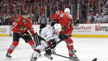 Jun 2, 2013; Chicago, IL, USA; Los Angeles Kings defenseman Drew Doughty (8) attempts to control the puck against Chicago Blackhawks left wing Brandon Saad (20) and center Michal Handzus (26) during the third period in game two of the Western Conference finals of the 2013 Stanley Cup Playoffs at the United Center. The Blackhawks beat the Kings 4-2. Mandatory Credit: Rob Grabowski-USA TODAY Sports