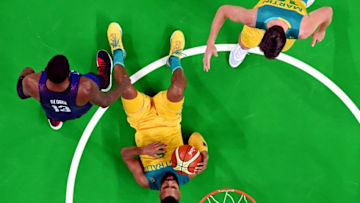 Aug 10, 2016; Rio de Janeiro, Brazil; Australia shooting guard Patty Mills (5) falls against USA guard Paul George (13) during men's basketball preliminary round in the Rio 2016 Summer Olympic Games at Carioca Arena 1. Mandatory Credit: USA TODAY Sports