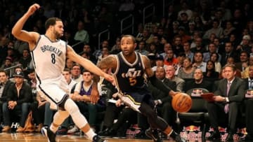 Dec 18, 2012; New York, NY, USA; Utah Jazz point guard Mo Williams (5) drives around Brooklyn Nets point guard Deron Williams (8) during the fourth quarter at Barclays Center. Utah won 92-90. Mandatory Credit: Anthony Gruppuso-USA TODAY Sports