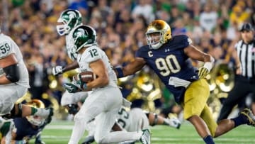 Sep 17, 2016; South Bend, IN, USA; Michigan State Spartans wide receiver R.J. Shelton (12) runs the ball in the fourth quarter as Notre Dame Fighting Irish defensive lineman Isaac Rochell (90) pursues in the fourth quarter at Notre Dame Stadium. MSU won 36-28. Mandatory Credit: Matt Cashore-USA TODAY Sports