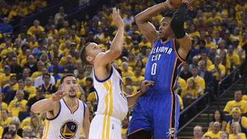 May 16, 2016; Oakland, CA, USA; Oklahoma City Thunder guard Russell Westbrook (0) passes the basketball against Golden State Warriors guard Klay Thompson (11) and guard Stephen Curry (30) during the third quarter in game one of the Western conference finals of the NBA Playoffs at Oracle Arena. The Thunder defeated the Warriors 108-102. Mandatory Credit: Kyle Terada-USA TODAY Sports