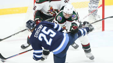 Nov 29, 2021; Winnipeg, Manitoba, CAN; Arizona Coyotes forward Antoine Roussel (26) bodies Winnipeg Jets forward Paul Stasny (25) during the third period at Canada Life Centre. Mandatory Credit: Terrence Lee-USA TODAY Sports