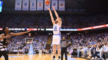 Feb 21, 2022; Chapel Hill, North Carolina, USA; North Carolina Tar Heels forward Brady Manek (45) shoots as Louisville Cardinals forward Jae'Lyn Withers (24) defends in the second half at Dean E. Smith Center. Mandatory Credit: Bob Donnan-USA TODAY Sports