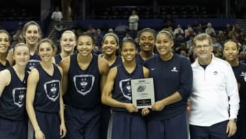 Apr 4, 2015; Tampa, FL, USA; Connecticut Huskies head coach Geno Auriemma (right) and his players pose for a photo during practice after receiving the NCAA award for top field goal percentage for the 2014-15 season the NCAA Womens Final Four at Amelie Arena. Mandatory Credit: Kim Klement-USA TODAY Sports