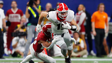 ATLANTA, GEORGIA - DECEMBER 04: Brock Bowers #19 of the Georgia Bulldogs is tackled by Josh Jobe #28 of the Alabama Crimson Tide during the third quarter of the SEC Championship game against the at Mercedes-Benz Stadium on December 04, 2021 in Atlanta, Georgia. (Photo by Todd Kirkland/Getty Images)