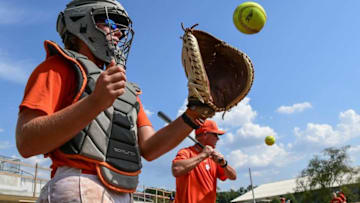 Clemson softball catcher Abby Stuart catches a ball near head coach John Rittman hitting infield grounders, during the first practice on their new field in Clemson Monday, September 30, 2019.Clemson Softball Practices On New Field For First Time