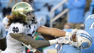 CHAPEL HILL, NORTH CAROLINA - NOVEMBER 27: Marist Liufau #35 of the Notre Dame Fighting Irish rushes against Michael Carter #8 of the North Carolina Tar Heels during the first half of their game at Kenan Stadium on November 27, 2020 in Chapel Hill, North Carolina. (Photo by Grant Halverson/Getty Images)