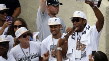 Jun 18, 2014; San Antonio, TX, USA; San Antonio Spurs forward Kawhi Leonard (right) hoists the trophy for the fans during the NBA championship parade at San Antonio River Walk. Mandatory Credit: Soobum Im-USA TODAY Sports