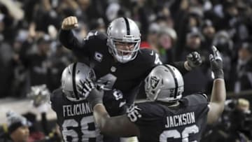 Dec 24, 2015; Oakland, CA, USA; Oakland Raiders quarterback Derek Carr (4) celebrates with offensive guard Jon Feliciano (68) and guard Gabe Jackson (66) after a touchdown in the fourth quarter against the San Diego Chargers during an NFL football game at O.co Coliseum. The Raiders defeated the Chargers 23-20 in overtime. Mandatory Credit: Kirby Lee-USA TODAY Sports
