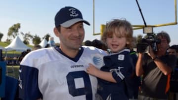 Jul 31, 2014; Oxnard, CA, USA; Dallas Cowboys quarterback Tony Romo (9) carries his son Hawkins Romo at training camp at the River Ridge Fields. Mandatory Credit: Kirby Lee-USA TODAY Sports