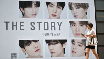 A woman walks past a poster for the BTS memoir titled "Beyond the Story: 10-Year Record of BTS" in front of a bookstore in Seoul on July 9, 2023. K-pop megastars BTS released a hot-anticipated memoir in South Korea on July 9, to mark their 10th anniversary. (Photo by Jung Yeon-je / AFP) (Photo by JUNG YEON-JE/AFP via Getty Images)