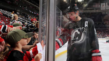 NEWARK, NEW JERSEY - NOVEMBER 15: Travis Zajac #19 of the New Jersey Devils greets his family during warm ups before the game against the Pittsburgh Penguins at Prudential Center on November 15, 2019 in Newark, New Jersey.The New Jersey Devils are wearing special jerseys for pregame warm ups in honor of Military Appreciation Night. (Photo by Elsa/Getty Images)