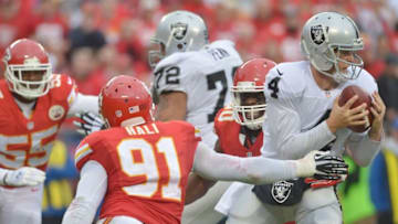 Dec 14, 2014; Kansas City, MO, USA; Oakland Raiders quarterback Derek Carr (4) prepares to throw the ball as Kansas City Chiefs outside linebacker Tamba Hali (91) and outside linebacker Justin Houston (50) defend during the second half at Arrowhead Stadium. The Chiefs won 31-13. Mandatory Credit: Denny Medley-USA TODAY Sports