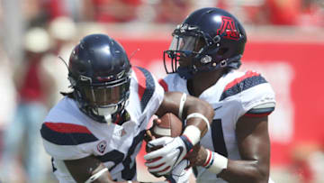HOUSTON, TX - SEPTEMBER 8: Khalil Tate #14 of the Arizona Wildcats pulls the ball back from Darrius Smith #20 of the Arizona Wildcats against the Houston Cougars in the third quarter at TDECU Stadium on September 8, 2018 in Houston, Texas. Houston won 45 to 18. (Photo by Thomas B. Shea/Getty Images)
