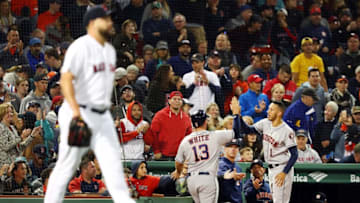 BOSTON, MA - September 9: Brian Johnson #61 of the Boston Red Sox looks on as Tyler White #13 high fives Carlos Correa #1 of the Houston Astros as he returns to the dugout after scoring to tie the game in the sixth inning at Fenway Park on September 9, 2018 in Boston, Massachusetts. (Photo by Adam Glanzman/Getty Images)