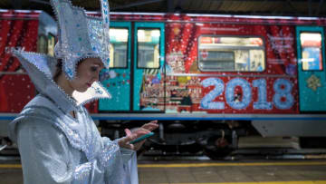 MOSCOW, RUSSIA - DECEMBER 21, 2017: A woman dressed as the Snow queen uses a mobile phone during the launching of the new Christmas and New Year's Eve themed train at Krasnaya Presnya Depot on Line 5 (Ring Line) of the Moscow Underground; named 'A Journey to Christmas', the new train features characters of fairy tales, sights of Moscow and pictures of winter. Sergei Bobylev/TASS (Photo by Sergei Bobylev\TASS via Getty Images)