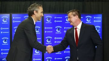 VANCOUVER, BC - MAY 23: Vancouver Canucks President Trevor Linden (L) shakes hands with Jim Benning as he introduces him as the team's new General Manager during a press conference at Rogers Arena May 23, 2014 in Vancouver, British Columbia, Canada. (Photo by Jeff Vinnick/NHLI via Getty Images)