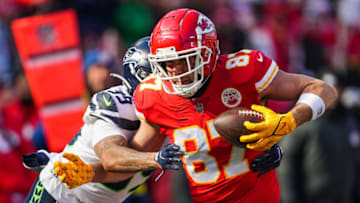 Dec 24, 2022; Kansas City, Missouri, USA; Kansas City Chiefs tight end Travis Kelce (87) carries the ball against Seattle Seahawks safety Teez Tabor (39) during the first half at GEHA Field at Arrowhead Stadium. Mandatory Credit: Jay Biggerstaff-USA TODAY Sports