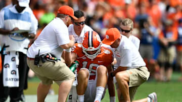 CLEMSON, SC - SEPTEMBER 29: Quarterback Trevor Lawrence #16 of the Clemson Tigers is helped from the field after taking a hard hit from the Syracuse Orange during the football game at Clemson Memorial Stadium on September 29, 2018 in Clemson, South Carolina. (Photo by Mike Comer/Getty Images)