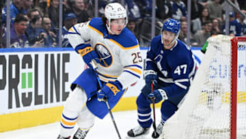 Apr 12, 2022; Toronto, Ontario, CAN; Buffalo Sabres defenseman Owen Power (25) skates the puck away from Toronto Maple Leafs forward Pierre Engvall (47) in the first period at Scotiabank Arena. Mandatory Credit: Dan Hamilton-USA TODAY Sports