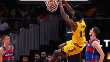 ATLANTA, GEORGIA - APRIL 06: Clint Capela #15 of the Atlanta Hawks dunks against Kristaps Porzingis #6 and Tomas Satoransky #31 of the Washington Wizards during the first half at State Farm Arena on April 06, 2022 in Atlanta, Georgia. NOTE TO USER: User expressly acknowledges and agrees that, by downloading and or using this photograph, User is consenting to the terms and conditions of the Getty Images License Agreement. (Photo by Kevin C. Cox/Getty Images)