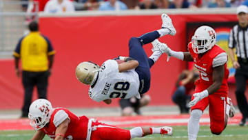 HOUSTON, TX - NOVEMBER 27: Dishan Romine #28 of the Navy Midshipmen is upended by D'Juan Hines #12 of the Houston Cougars and Adrian McDonald #16 after a catch in the second quarter at TEDECU Stadium on November 27, 2015 in Houston, Texas. (Photo by Bob Levey/Getty Images)