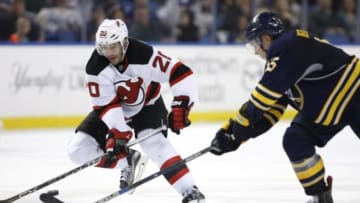 Dec 15, 2015; Buffalo, NY, USA; New Jersey Devils right wing Kyle Palmieri (21) and Buffalo Sabres defenseman Rasmus Ristolainen (55) go after the puck during the third period at First Niagara Center. New Jersey beats Buffalo 2 to 0. Mandatory Credit: Timothy T. Ludwig-USA TODAY Sports