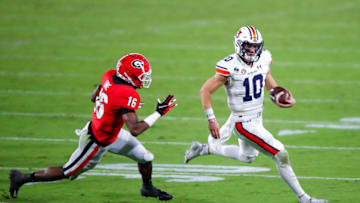 Bo Nix of the Auburn Tigers scrambles as he is pursued by Lewis Cine. (Photo by Todd Kirkland/Getty Images)