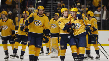 Yakov Trenin #13, Nick Cousins #21 and Matt Benning #5 of the Nashville Predators celebrate after a 4-3 overtime victory over the Montreal Canadiens at Bridgestone Arena on December 04, 2021 in Nashville, Tennessee. (Photo by Frederick Breedon/Getty Images)