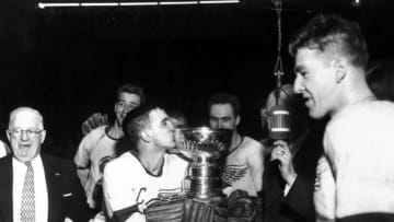 DETROIT, MI - APRIL 16: Ted Lindsay #7 of the Detroit Red Wings kisses the cup as manager Jack Adams and the rest of the Wings celebrate winning the Stanley Cup after beating the Montreal Canadiens in Game 7 of the Stanley Cup Playoffs on April 16, 1954 at Olympia Stadium in Detroit, Michigan. The Red Wings defeated the Canadiens 2-1 in overtime. (Photo by Bruce Bennett Studios via Getty Images Studios/Getty Images)